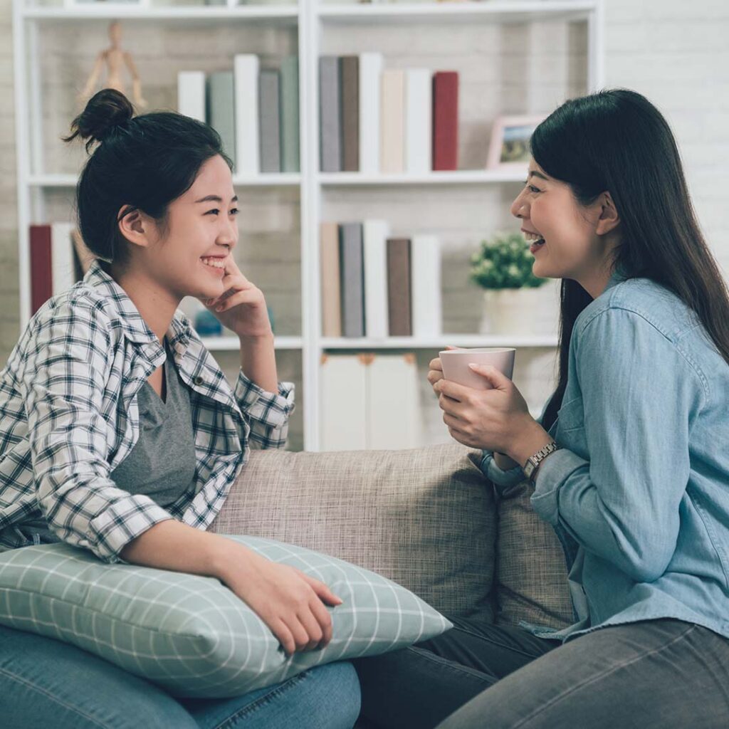 Photo of two women chatting on a couch